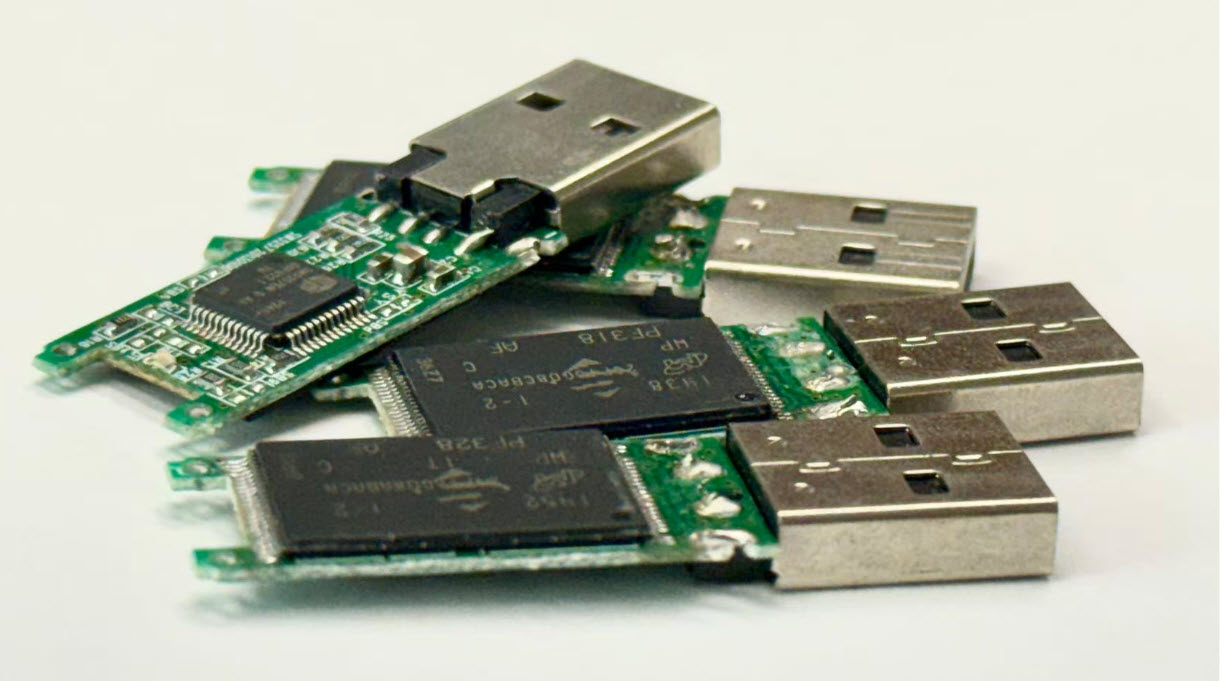 Factory technician reviewing NAND flash memory options for a USB drive production change